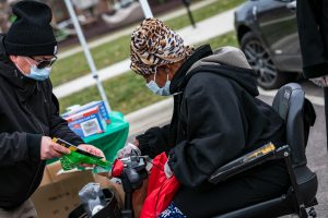 woman in motorized chair receives resources at outdoor resource event