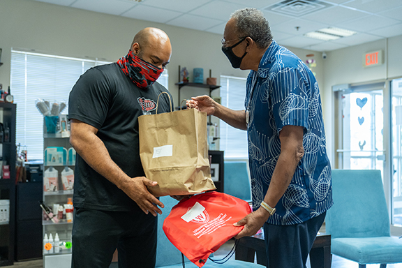 two men with a bag of take-out food